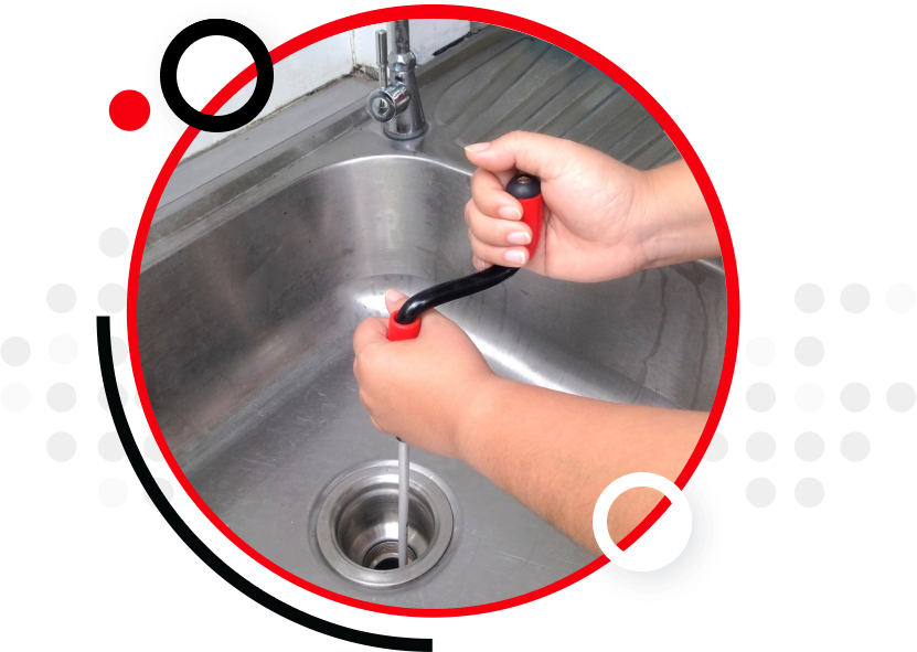 A plumber has inserted a drain snake to unclog a kitchen sink drain